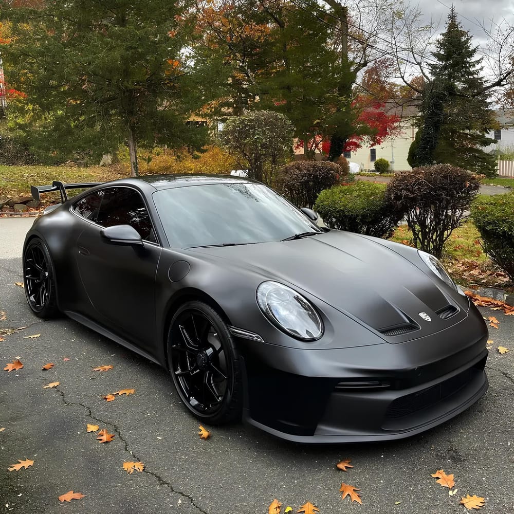 PPF ou covering noir satiné : Porsche 911 à aileron garée dans une allée en automne