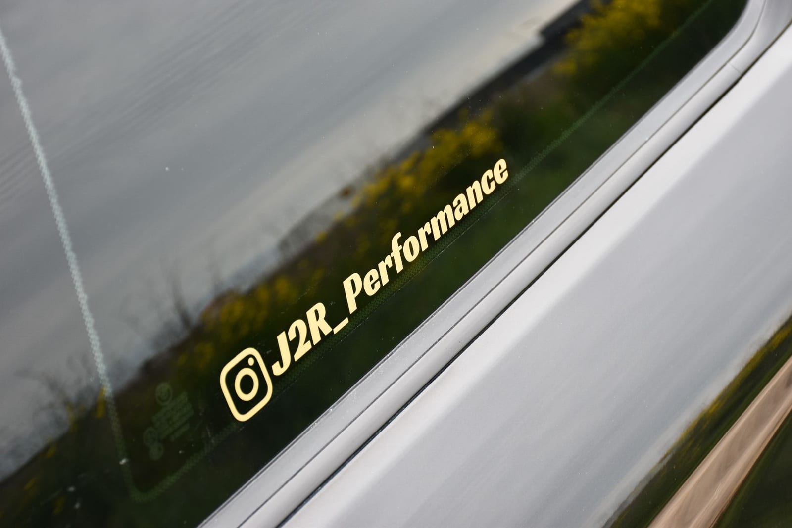 Sticker personnalisé doré collé sur la vitre d'une voiture